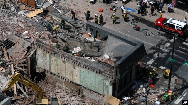 Rescue personnel search the scene of a building collapse in downtown Philadelphia, Pennsylvania, June 5, 2013.