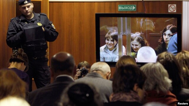 A bailiff stands in a room as people watch a live broadcast of a court hearing on members of the female punk band 'Pussy Riot' in Moscow October 10, 2012.