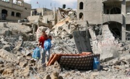Mpalestina akibeba vita vyake alivyopata baada ya nyumba take kubomolewa huko Beit Hanoun Julai 26, 2014.