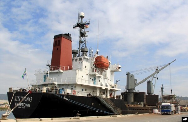 FILE - In this March 4, 2016 file photo, crewmen of the North Korean cargo vessel Jin Teng stand on the middle of the deck as it unloads its cargo while docked at Subic Bay, in Zambales province, northwest of Manila, Philippines.