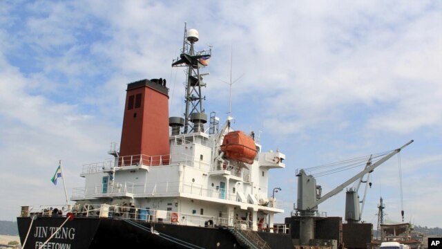 FILE - In this March 4, 2016 file photo, crewmen of the North Korean cargo vessel Jin Teng stand on the middle of the deck as it unloads its cargo while docked at Subic Bay, in Zambales province, northwest of Manila, Philippines. 