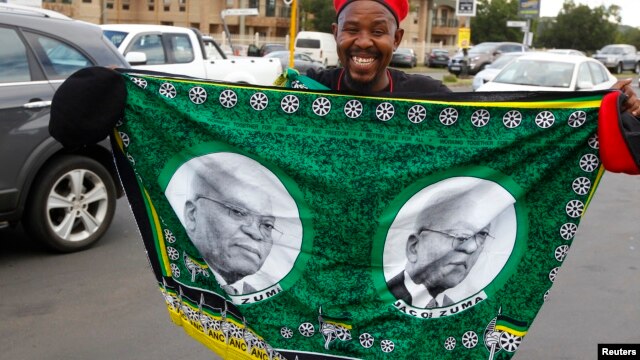 A supporter holds a flag depicting President Jacob Zuma during celebrations as delegates to the National Conference of the ruling African National Congress vote for their leadership in Bloemfontein, December 17, 2012. 