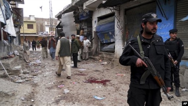 Polisi Pakistan memeriksa lokasi kejadian pasca ledakan di Hangu, Pakistan, 1 Februari 2013. (AP Photo/Abdul Basit). 