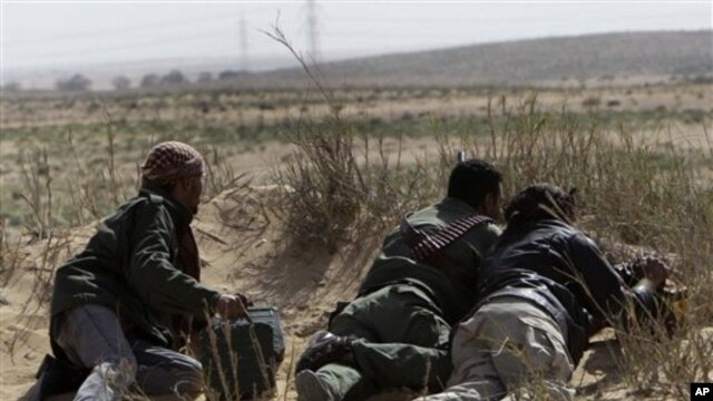 Libyan rebel take their position during a battle against pro-Moaamar Gadhafi fighters, in the town of Brega, east of Libya, March 2, 2011.