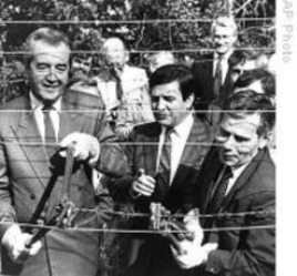 Hungarian Foreign Minister Gyula Horn (r) with Austrian counterpart Alois Mock cut through barbed wire of former Iron Curtain marking border between East, West in Sopron, Hungary, 27 Jun 1989