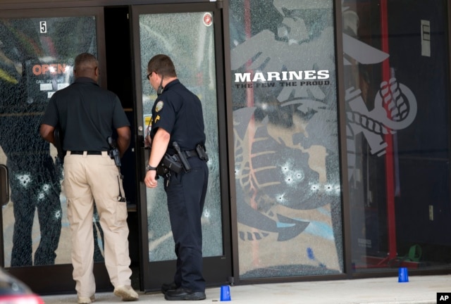 Police officers enter the Armed Forces Career Center through a bullet-riddled door after a gunman opened fire on the building in Chattanooga, Tennessee, July 16, 2015.