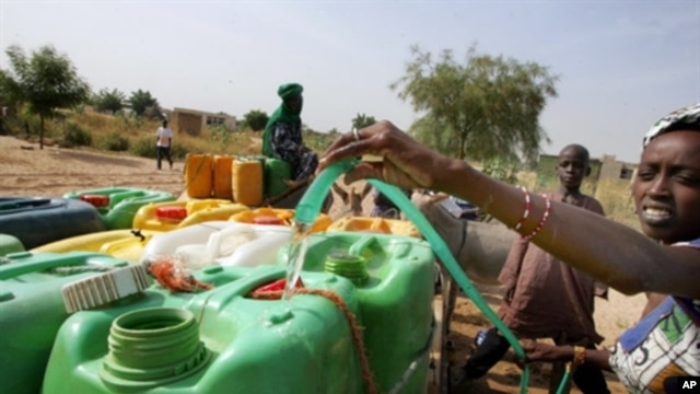 A woman fills cans of water in Touba, Senegal, 01 Nov 2007 (file photo)