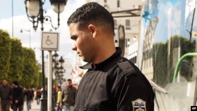 A Tunisian policeman wears a red armband showing solidarity with the demonstrators in Tunis, Tunisia, 22 Jan 2011