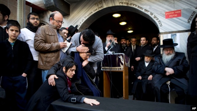 Family and relatives of Yoav Hattab, a Jewish victim of the attack on a kosher grocery store in Paris, gather around a symbolic coffin for his funeral procession in the city of Bnei Brak near Tel Aviv, Israel, Jan. 13, 2015.