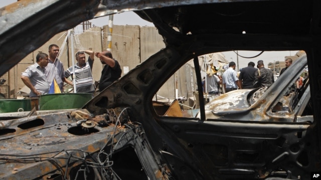People gather at the scene of a bomb attack in Baghdad's Shiite enclave of Sadr City, Iraq, Monday, July 23, 2012.