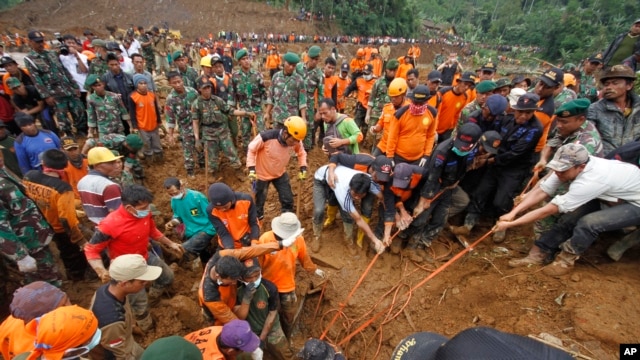 Nhân viên cứu hộ kéo một thi thể nạn nhân trong vụ đất chuồi vùi lấp một ngôi làng ở Jemblung, Trung Java, Indonesia, ngày 14 tháng 12, 2014.