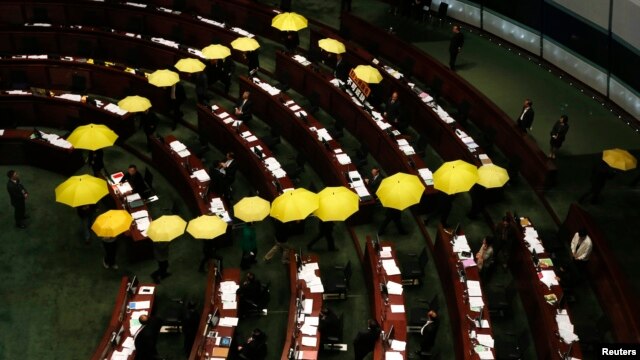 Các nhà lập pháp Hong Kong ủng hộ dân chủ cầm những chiếc dù mầu vàng, biểu tưởng của phong trào Chiếm Trung rời khỏi phòng họp như một cử chỉ tẩy chay chính phủ Hong Kong 7/1/15