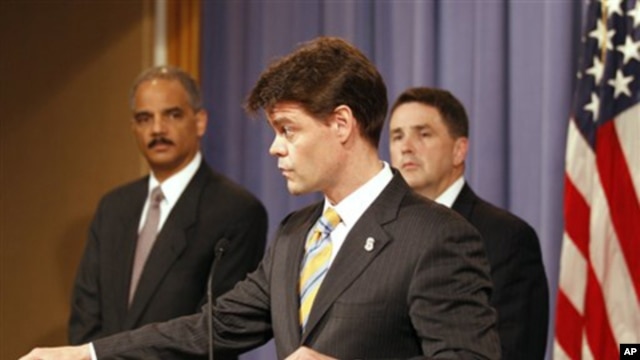 Attorney General Eric Holder, left, listens as U.S. Immigration and Customs Enforcement Assistant Secretary John Morton speaks during a news conference at the Justice Department in Washington, 10 June 2010