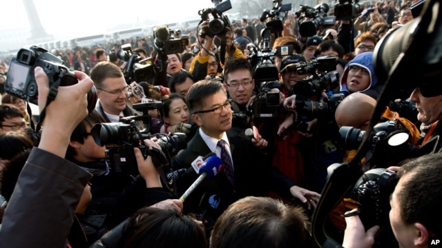 U.S. Ambassador to China Gary Locke, center, is mobbed by journalists as he attends the opening session of the annual National People's Congress at the Great Hall of the People in Beijing, China, Mar. 5, 2013. 