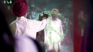 This screenshot from Coca-Cola's short film "Small World Machines" shows two men from India and Pakistan reaching out to each other through high-tech touchscreens in Lahore and New Delhi.