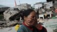 A village woman reacts after her house was damaged by an earthquake in Lushan county, Ya