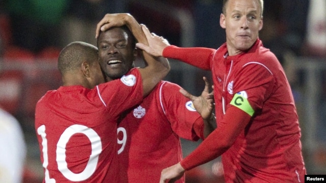 Canada's Simeon Jackson (L) and Kevin McKenna (R) celebrate with teammate Tosaint Ricketts after he scored on Cuba in the first half of their 2014 FIFA World Cup qualifying soccer match in Toronto, October 12, 2012.  