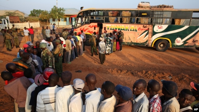 FILE - Passengers hoping to travel to Nairobi line up at a bus in the town of Mandera near the Kenya-Somalia border, Dec. 8, 2014.