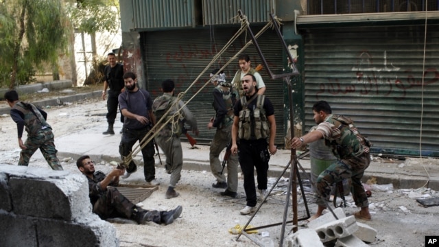 Members of the Free Syrian Army use a catapult to launch a homemade bomb during clashes with pro-government soldiers in the city of Aleppo, October 15, 2012. 