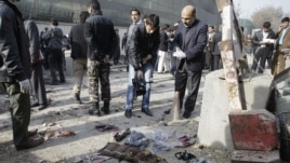 An Afghan cameraman films the vest of an attacker and arms collected from the scene of a suicide attack in Kabul, Afghanistan, ,November 21, 2012. 