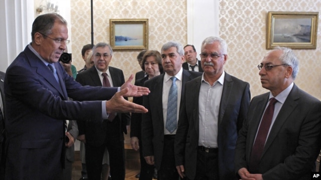 Russian Foreign Minister Sergey Lavrov, left, welcomes a delegation headed by a leader of the Syrian National Council, Abdulbaset Sieda, right, in Moscow, Russia, July 11, 2012.