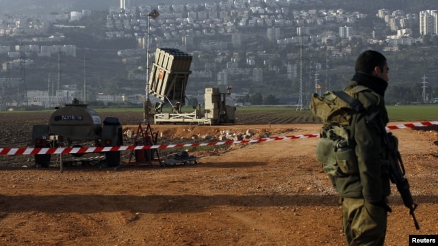 An Israeli soldier stands guard next to an Iron Dome rocket interceptor battery deployed near the northern Israeli city of Haifa, January 28, 2013.