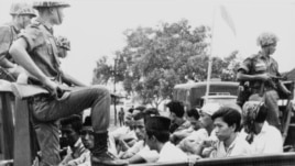 Anggota organisasi pemuda PKI dijaga tentara saat diangkut ke truk terbuka ke penjara di Jakarta, 30 Oktober 1965.