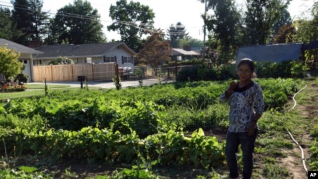 Farmer Pabi Tiwari,  who moved to Oregon from a Nepalese refugee camp, enjoys a lemon cucumber fresh from the fields.