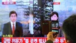 South Korean man uses his smartphone to take a photo of television screen reporting news about North Korea's rocket launch at Seoul Railway Station in Seoul, South Korea, December 12, 2012.