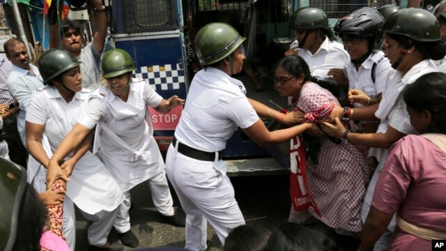 Indian policewomen detain an activist of Socialist Unity Center of India during a daylong nationwide strike in Kolkata, India, Sept. 2, 2015.