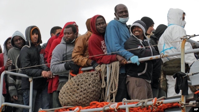 Migrants wait to disembark from a tug boat after being rescued in Porto Empedocle, Sicily, southern Italy, Feb. 17, 2015.