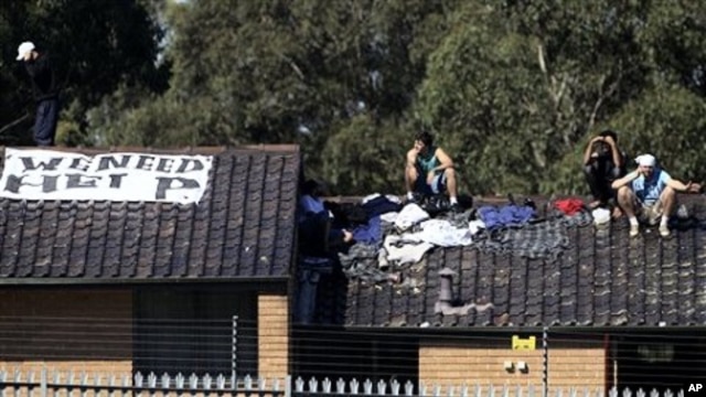 Five detainees gather on a rooftop of the Villawood Detention Center in Sydney, Australia, April 21, 2011