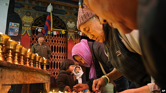 Tibetan Buddhist exiles offer prayers as they light butter lamps to show solidarity with Tibetans who have either set themselves on fire or were allegedly injured or killed in clashes with Chinese police, in New Delhi, India, February 9, 2012.