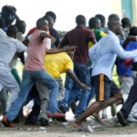 Supporters of Congolese opposition leader Etienne Tshisekedi run as riot police charge with tear gas and live fire outside their candidate's headquarters in Kinshasa, Democratic Republic of Congo, December 8, 2011