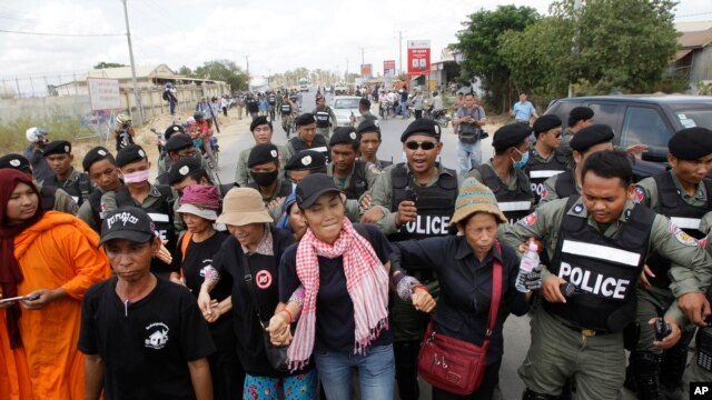 FILE - Cambodian civil rights supporters are forcibly directed by riot police as they march in protest of charges brought against local rights activists near  Prey Sar prison, outside Phnom Penh, Cambodia, May 9, 2016. 