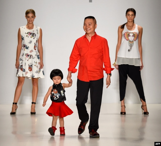 Designer Zhuliang Li (C) appears on the runway with model Danielle Knudson (L) and Miss Teen USA K. Lee Graham (R) at the Oudifu fashion show during Mercedes-Benz Fashion Week Spring 2015.