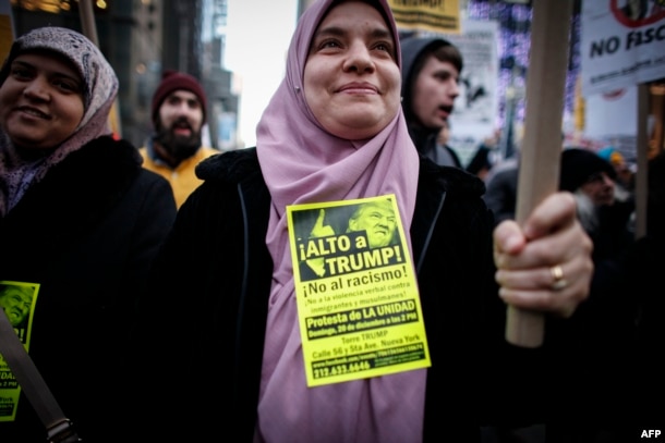FILE - A Muslim woman holds a poster during a protest against Donald Trump in New York, Dec. 20, 2015.