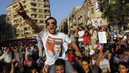 An Egyptian supporter of Muslim brotherhood candidate Mohammed Morsi wearing a shirt with Arabic that reads, "'Mohammed Morsi, president for Egypt" chants slogans in Tahrir Square, Cairo, Egypt, June 18, 2012.