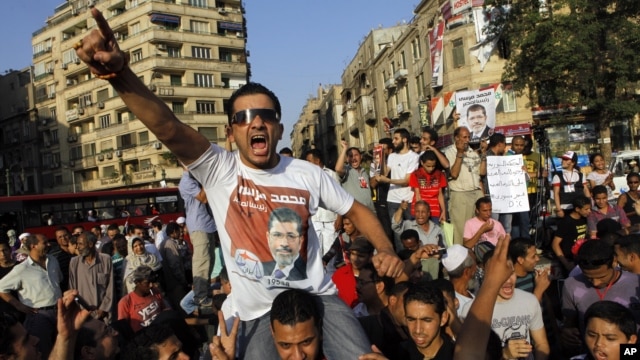 An Egyptian supporter of Muslim brotherhood candidate Mohammed Morsi wearing a shirt with Arabic that reads, "'Mohammed Morsi, president for Egypt" chants slogans in Tahrir Square, Cairo, Egypt, June 18, 2012.