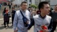 Sun Wenlin, right, and partner Hu Mingliang leave the court after a judge ruled against them in China's first gay marriage case in Changsha in central China's Hunan province, April 13, 2016. Several hundred supporters cheered them on at the courthouse.