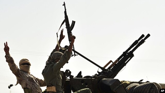 Anti-Gadhafi fighters with weapons move to the front line, 90 km east of Sirte, from Om El Qandil, 90 km west of Ras Lanuf September 6, 2011.