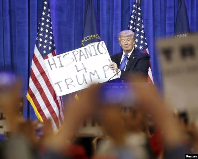 FILE - Republican U.S. presidential candidate Donald Trump holds up a sign from the audience as he speaks to supporters at a Super Tuesday campaign rally in Louisville, Kentucky, March 1, 2016.