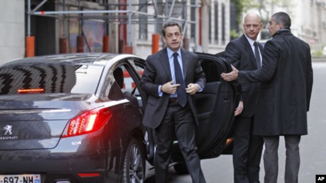 France's President and UMP party candidate for the 2012 French presidential elections Nicolas Sarkozy (L) arrives to attend an interview at the RTL radio station studios in Paris, April 20, 2012. 