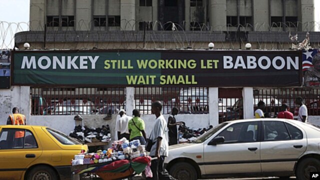 An election poster for Liberian President Ellen Johnson Sirleaf is seen in the heart of the Liberian capital Monrovia. Her slogan "Monkey Still Working Baboon Wait Small" implies she needs a second term to complete her agenda, and currently appears on pos