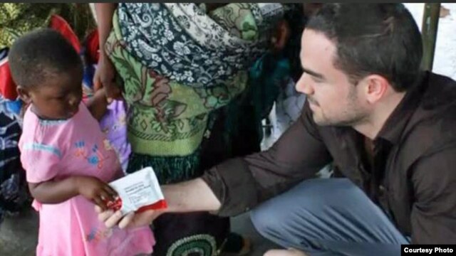 Two Degrees co-founder Will Hauser gives a prepared food packet to a child in Malawi. (Courtesy Two Degrees)
