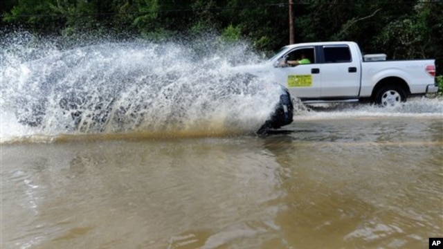 Motorists drive through a flooded street in Leonardtown, Maryland., after Hurricane Irene, Sunday, Aug. 28, 2011