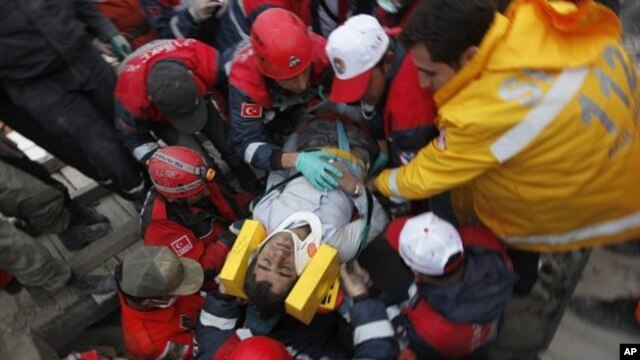 Emergency service workers carry an earthquake survivor during rescue operations in Ercis, near the eastern Turkish city of Van, October 24, 2011.