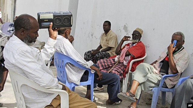 Somalis listen to news from the London conference on a radio in Mogadishu, Somalia, February 23, 2012.