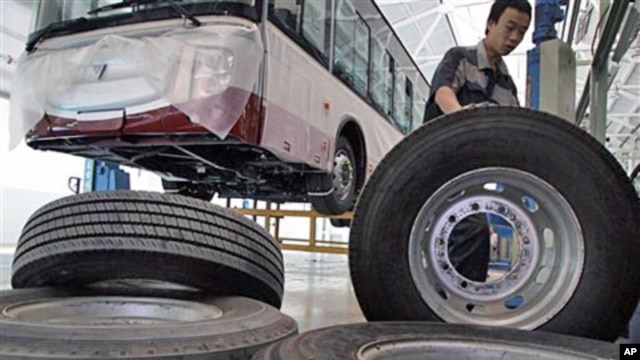 A Chinese worker moves large tires at an assembly line for buses made by Chinese auto manufacturer Foton Motor Group in Beijing (File)