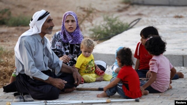 New Syrian refugees rest as they arrive at a stopover facility near the Turkish border town of Reyhanli in Hatay province, August 9, 2012. 